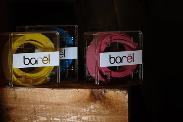 Three multicoloured silicone belts displayed on wooden block at NYLA Fresh Thread's Nanaimo store