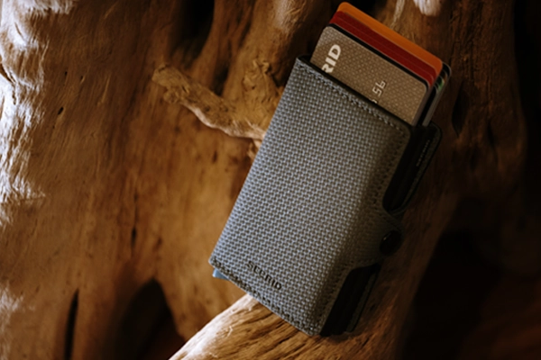 Grey Secrid Twinwallet displayed on wooden branch at NYLA Fresh Thread's Nanaimo store